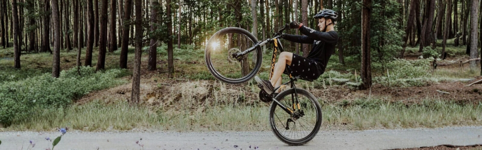 Vozač BMX-a izvodi trik u šumi